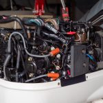 Mechanic repairing an outboard engine with the engine cowling removed