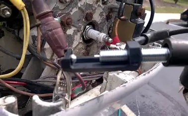 Mechanic testing the spark on a Mercury outboard engine.